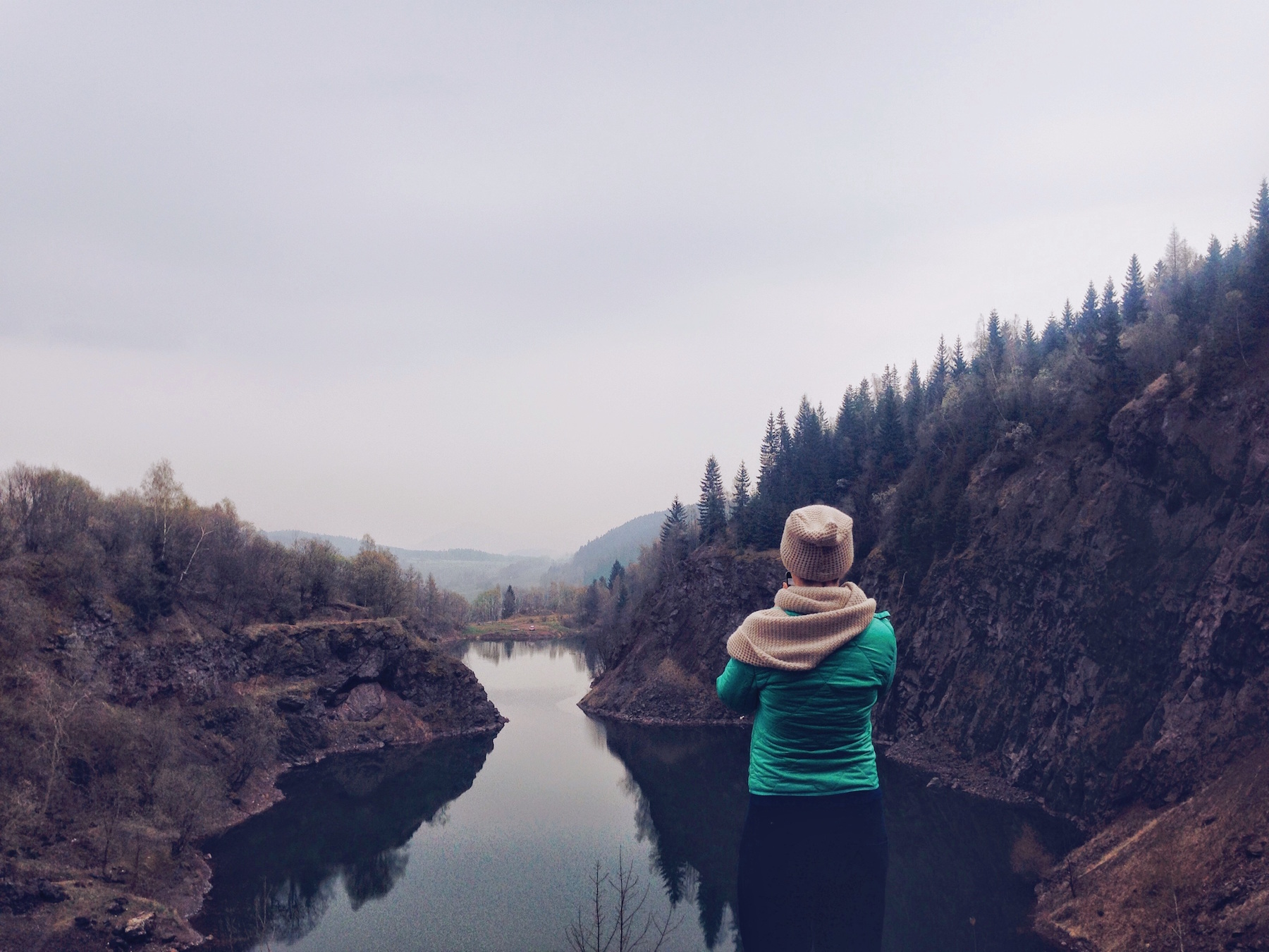 Frau mit Blick auf einen Fluss und Berge